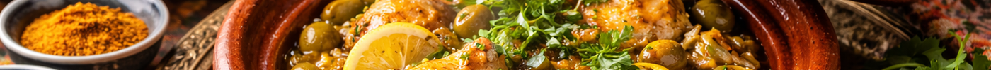 Aardewerk tajine met opgetild deksel, gevuld met kip, olijven en citroen, omringd door kruiden en specerijen