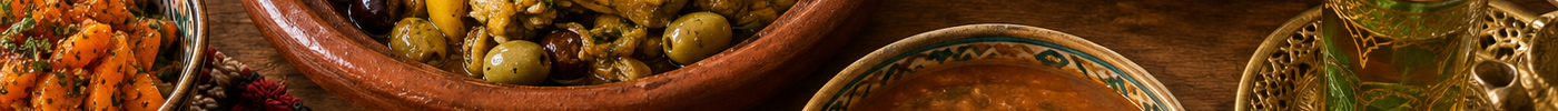 Marokkaanse maaltijd met tajine, harira, couscous, salades en muntthee op tafel